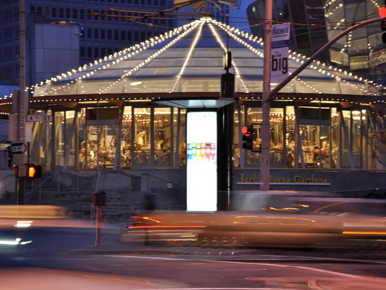 In this image we can see buildings, there are the lights, there is the hoarding, there is the pole,...