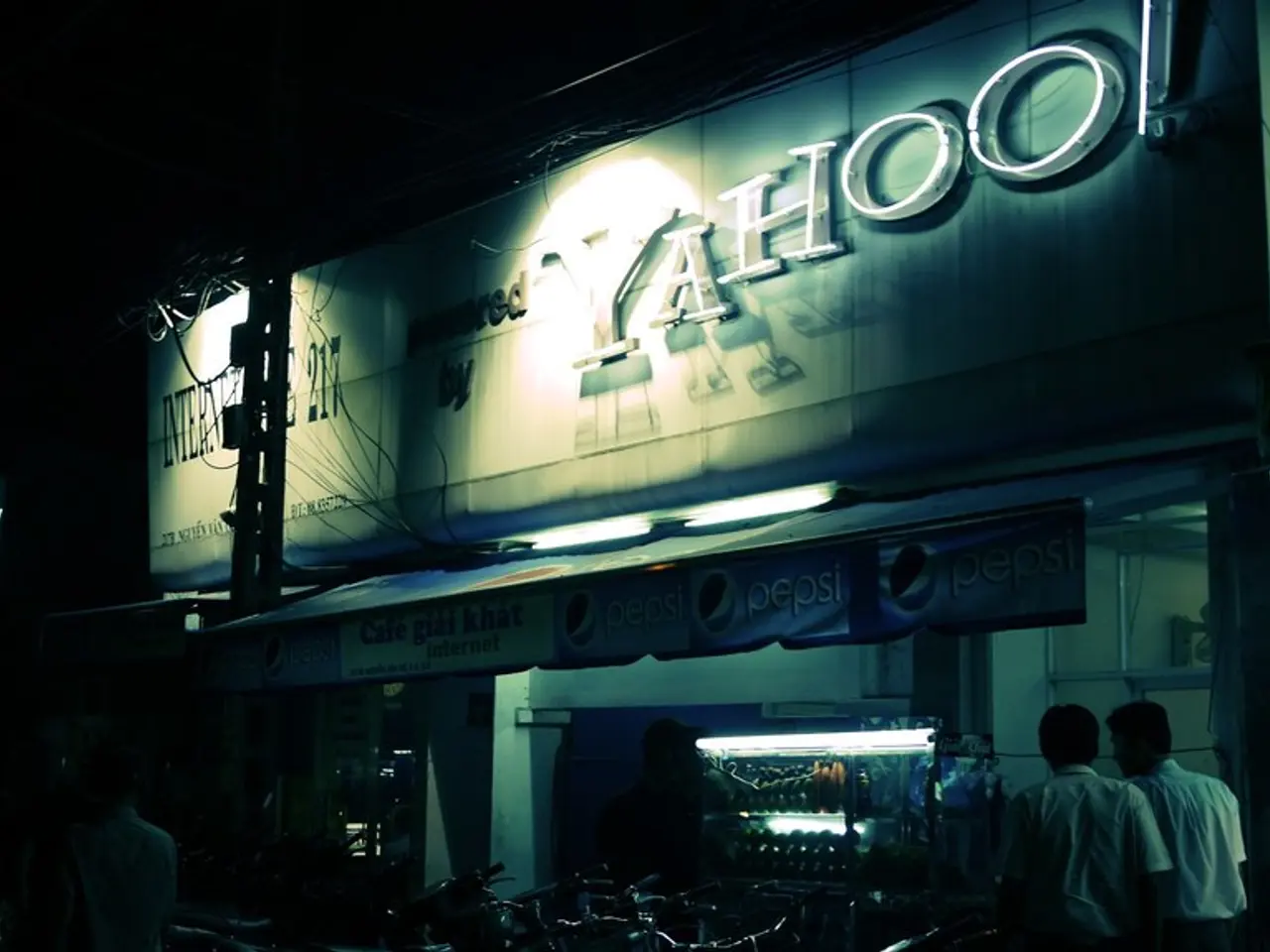 In this image we can see a building with text, there is an advertising board, a shed attached to...