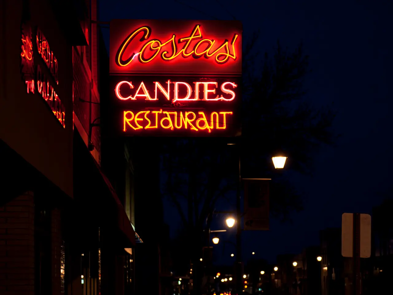 The picture is taken at the night time on a street. On the left side there are buildings. In the...