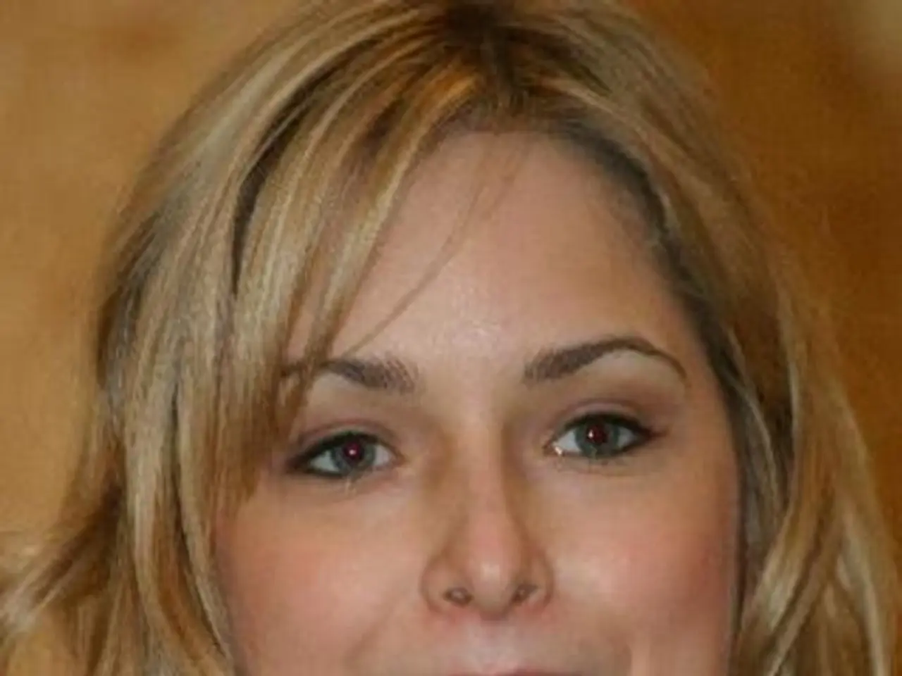 In this picture we can see a beautiful girl with golden brown hair is smiling and holding the...