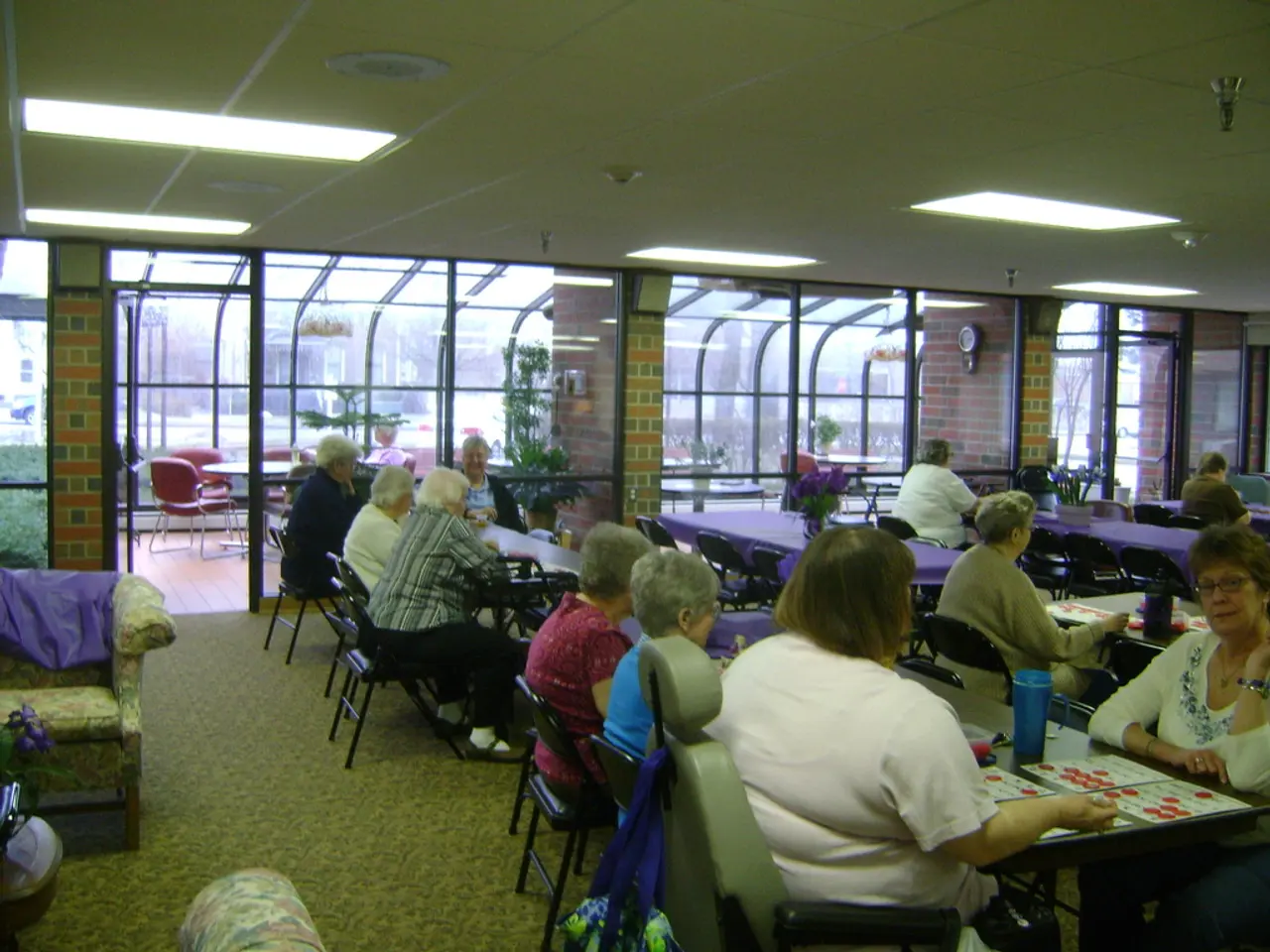 The image is clicked inside the room. There are many people sitting in their chairs near the...