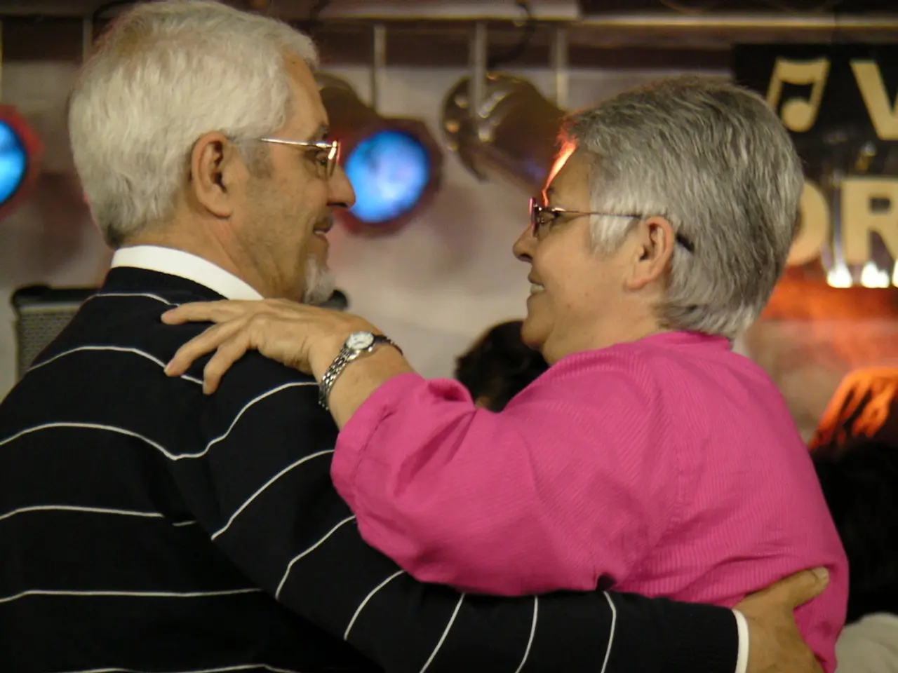 In this picture there is a man and a woman in the center of the image, they are dancing and there...