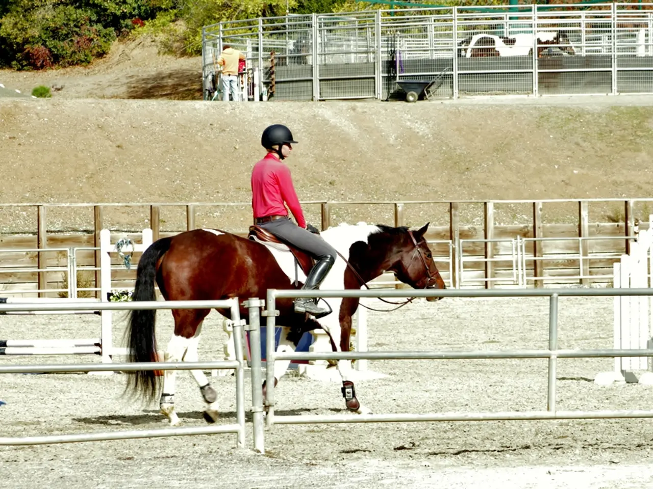In this image we can see a person wearing red color dress, helmet and long boots is sitting on the...