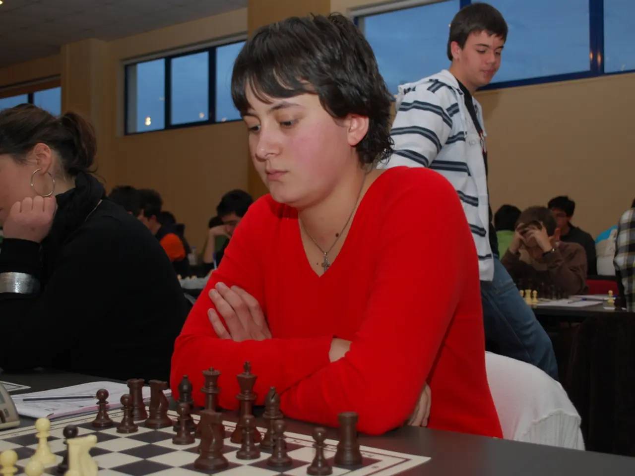 In this image there are group of persons who are playing chess at the middle of the image there is...