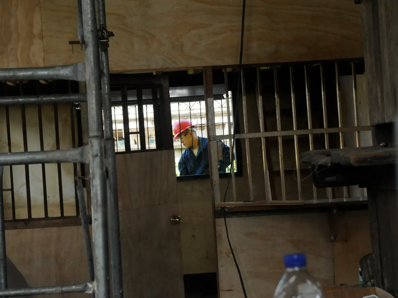 Outside of this window a man is standing wore a red helmet. This is door. This is ladder. This is...