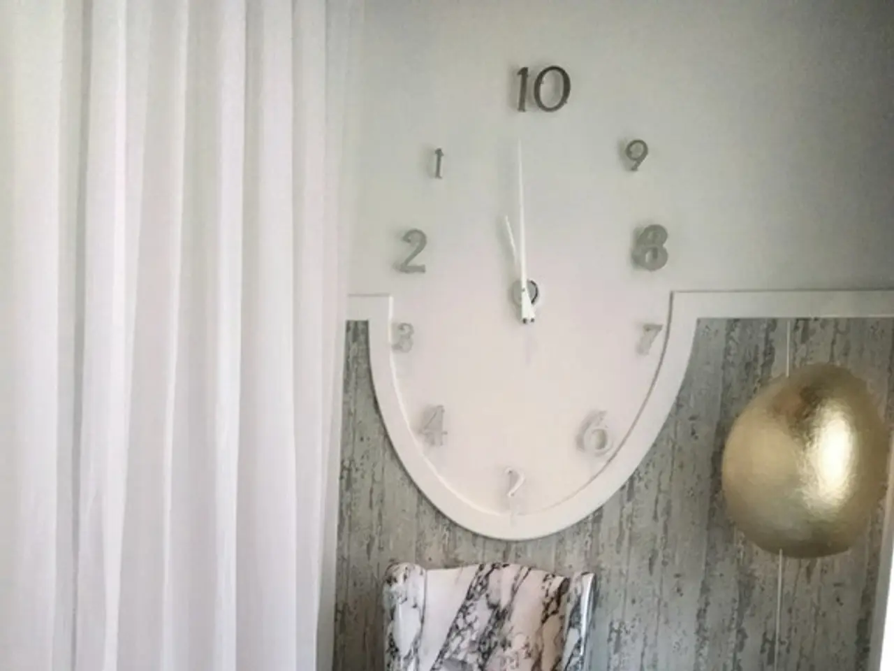 In this picture we can see a chair, table, curtain, cloth, carpet, house plant, wall and a steel...