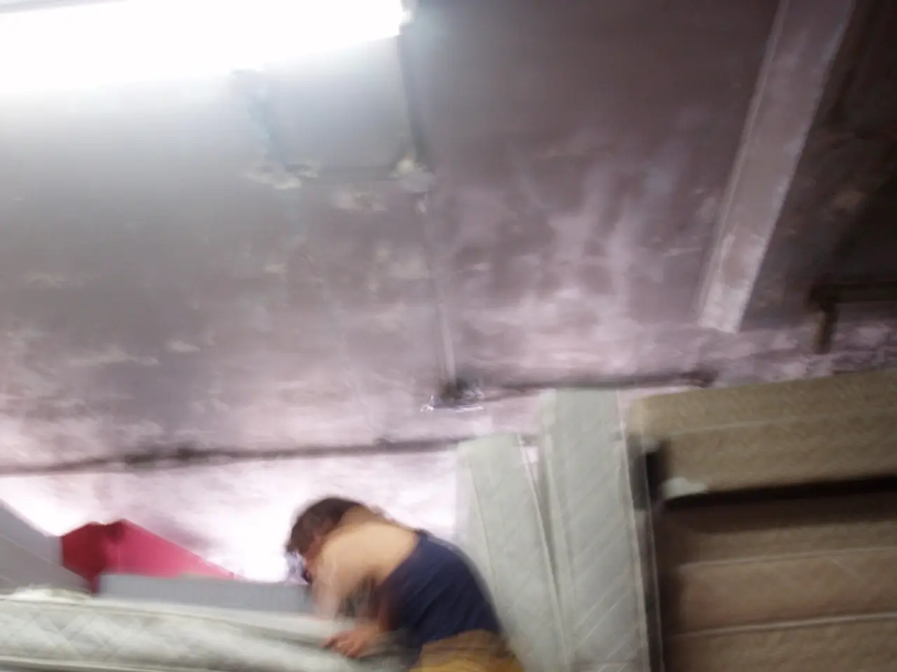 In this picture there is a women wearing a blue top and yellow jeans trying to climbing on the...