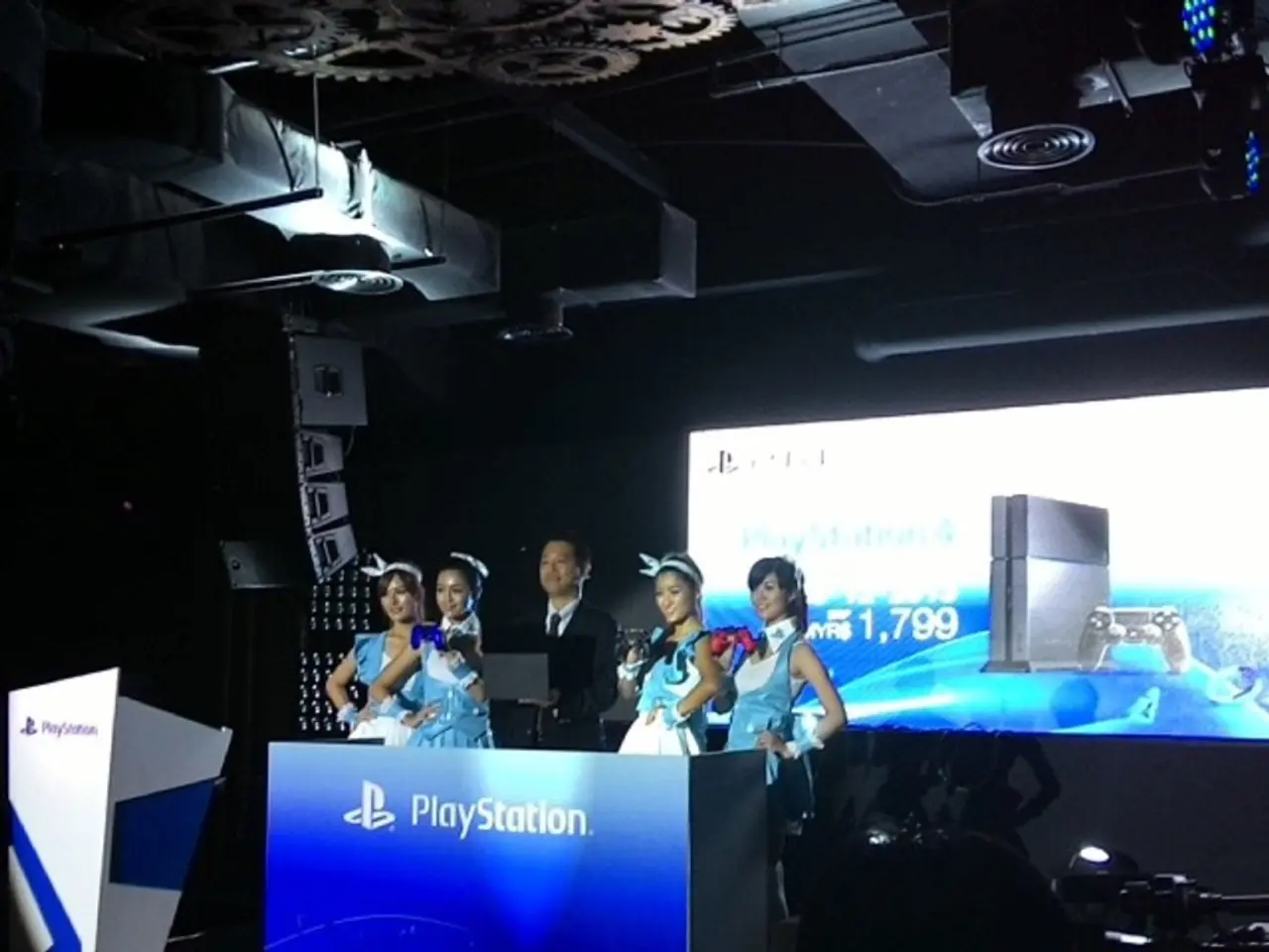 In the image we can see there are people standing on the stage near the podium and its written...