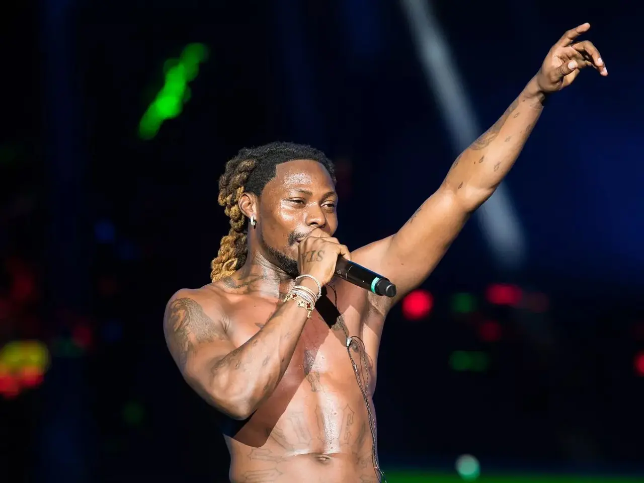 The image shows Travis Scott performing at the Coachella Valley Music and Arts Festival in Indio,...