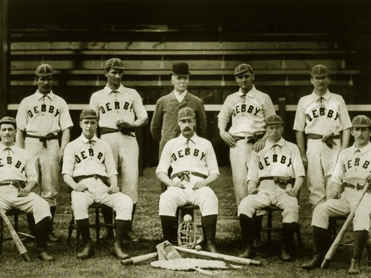 The image shows a black and white photo of a baseball team from the 1920s, with some of the players...