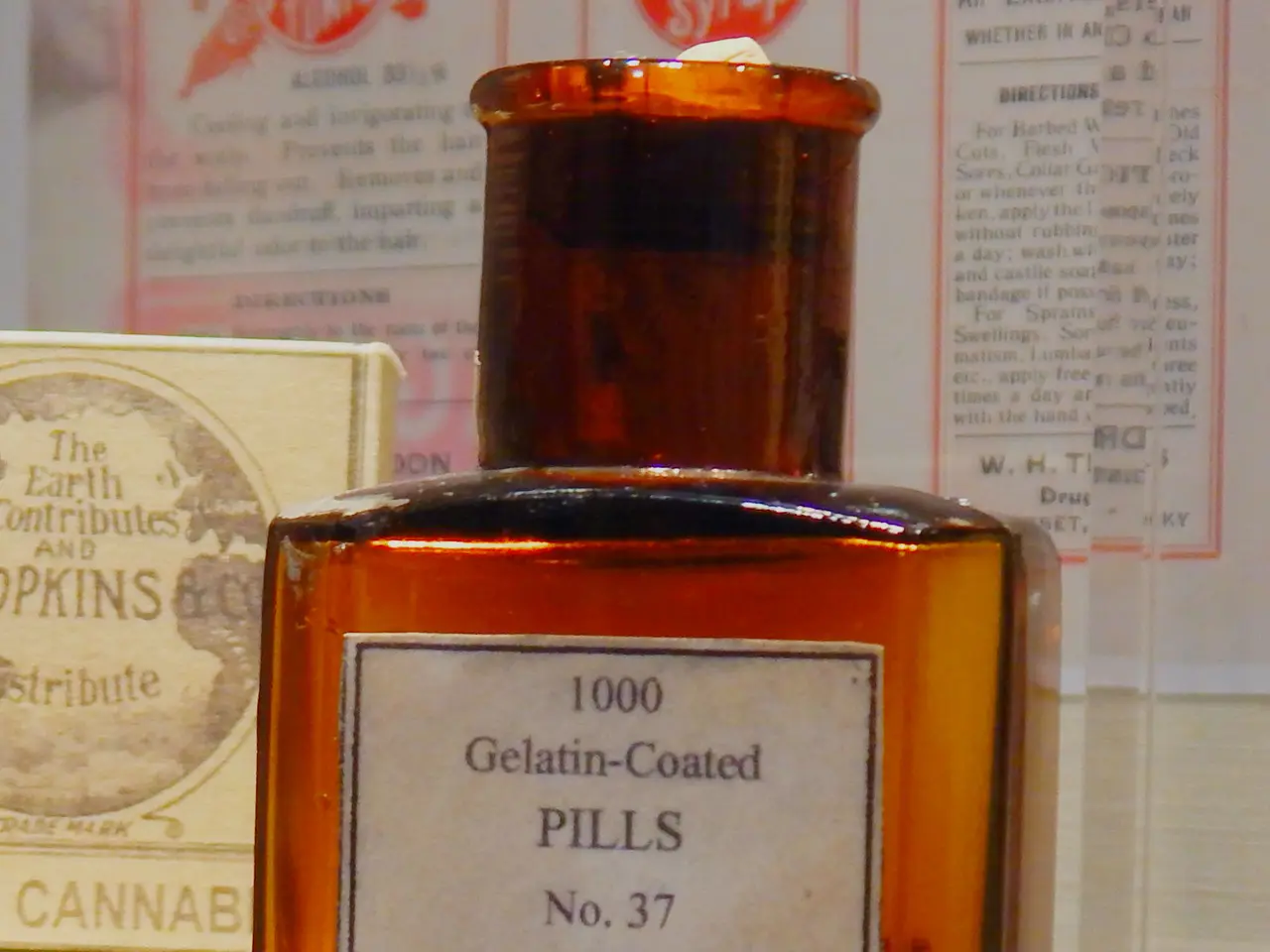 The image shows a bottle of cannabis indica extract sitting on top of a glass table, with a label...