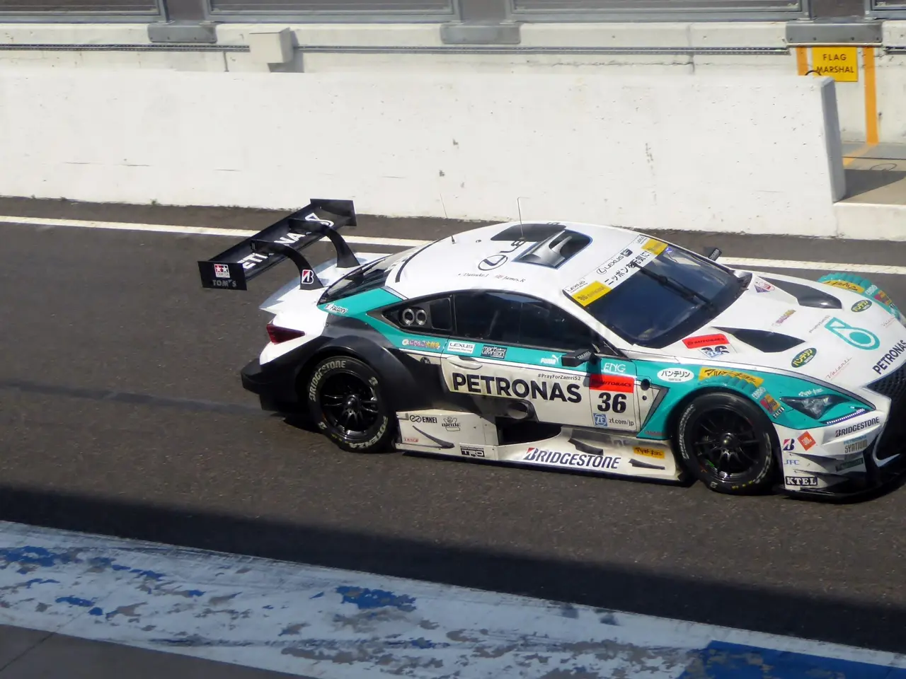 The image shows a Mercedes-AMG GT3 race car driving on a race track, with text on the car and a...