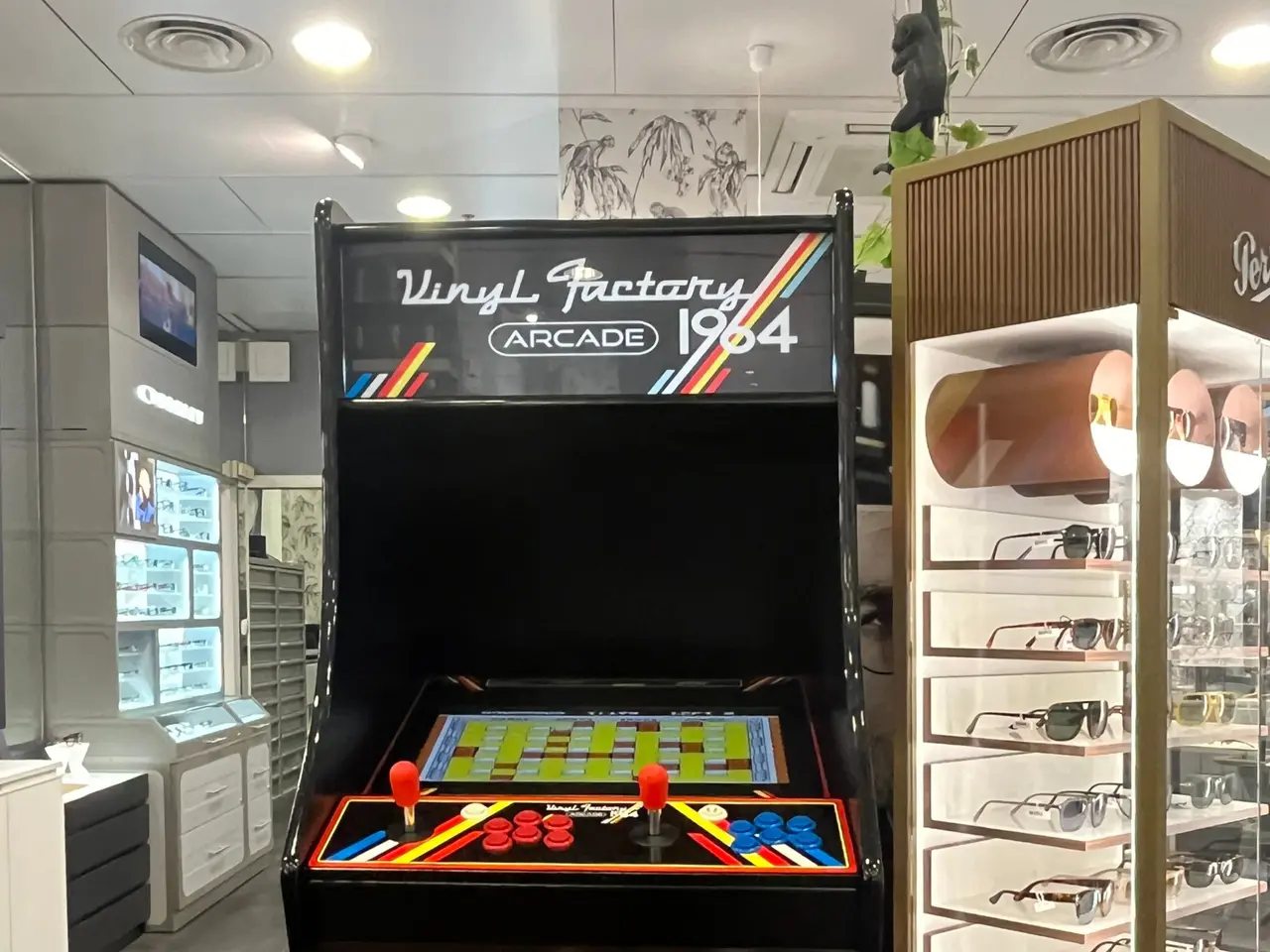 The image shows a store with a vintage arcade machine in the middle of it. On the right side of the...