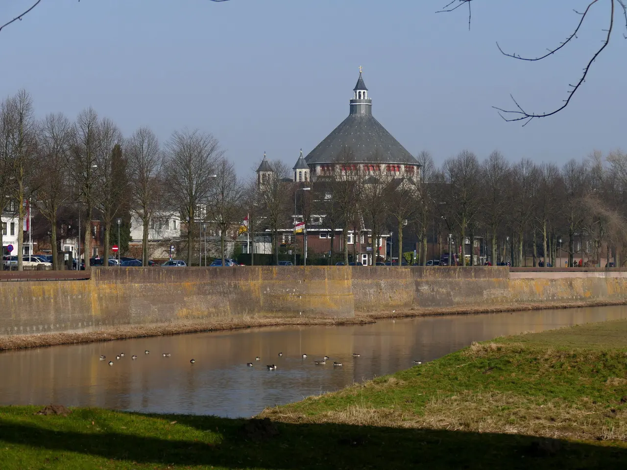 The image shows a river with ducks swimming in it, surrounded by lush green grass and trees. In the...