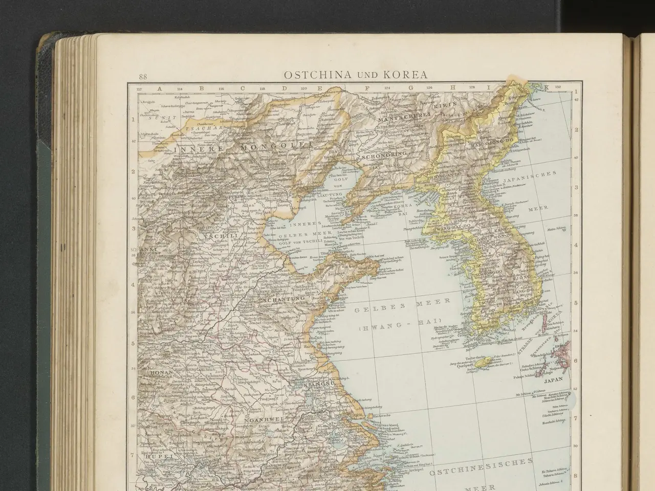 The image shows an open book with a map of South Korea on it, set against a black background. The...