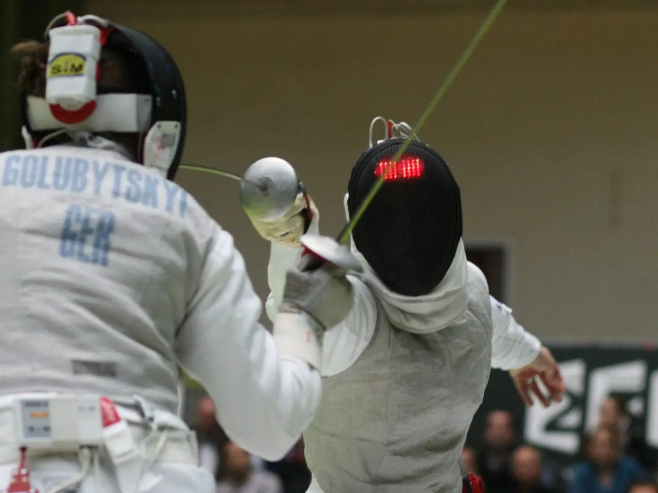 The image shows two fencers in action at the Olympics, both wearing white fencing costumes and...