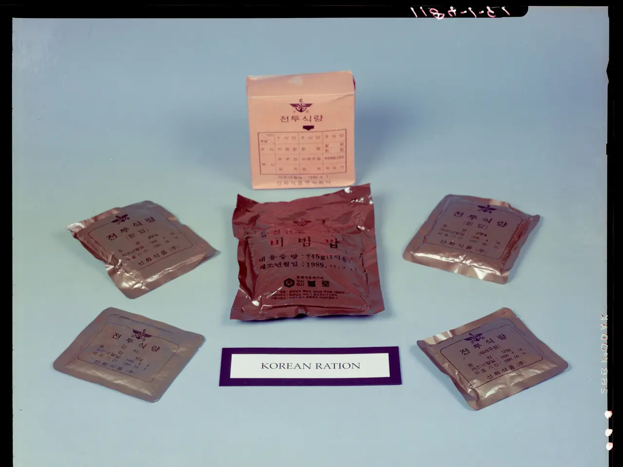 The image shows a blue surface with a few packets and a paper with text written on it, as well as a...