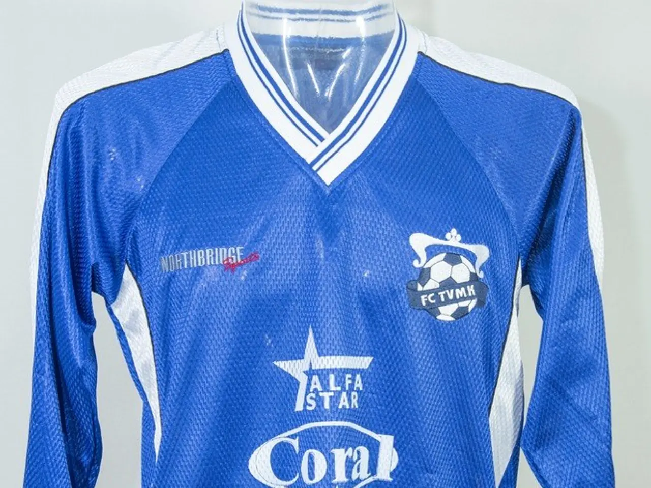 The image shows a mannequin wearing a blue and white soccer jersey with a logo on it against a...