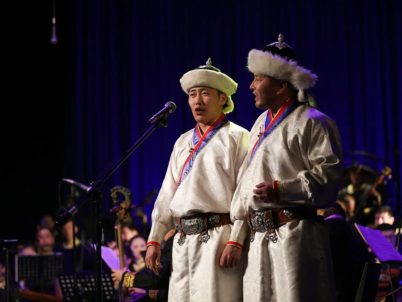 The image shows two men in traditional Korean clothing standing next to each other in front of a...