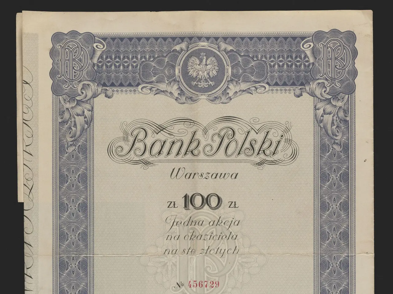 The image shows an old banknote with a blue border on a black background. The paper has text and a...