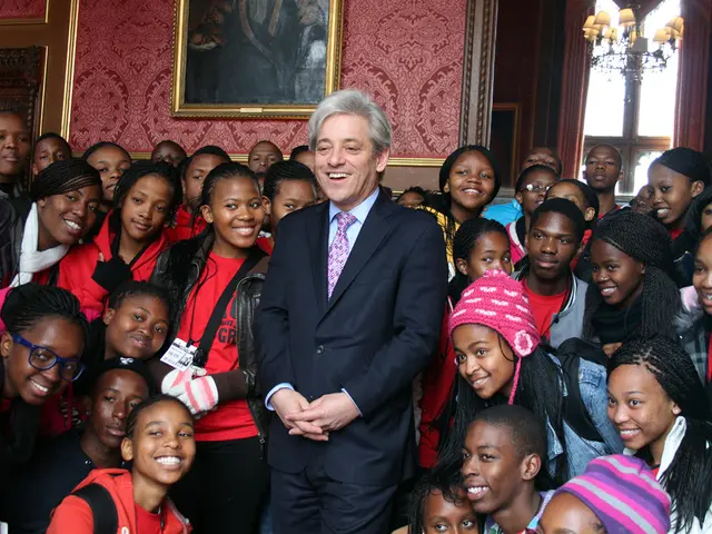 Here we can see group of people and they are smiling. In the background we can see a frame, wall,...