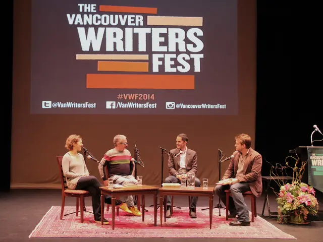 In the picture there are few men and a woman sat on chair on a stage talking on mic. It seems to be...