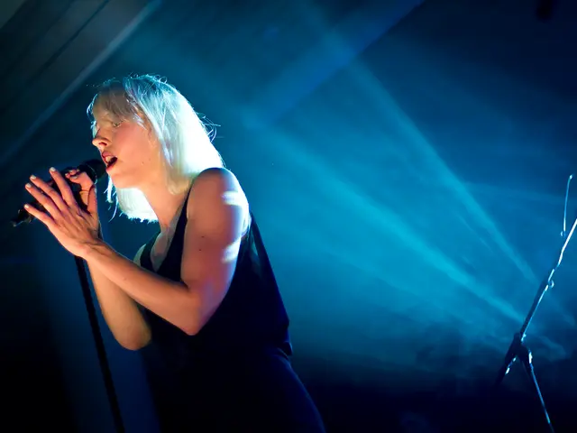 Here we can see a woman who is singing on the mike.