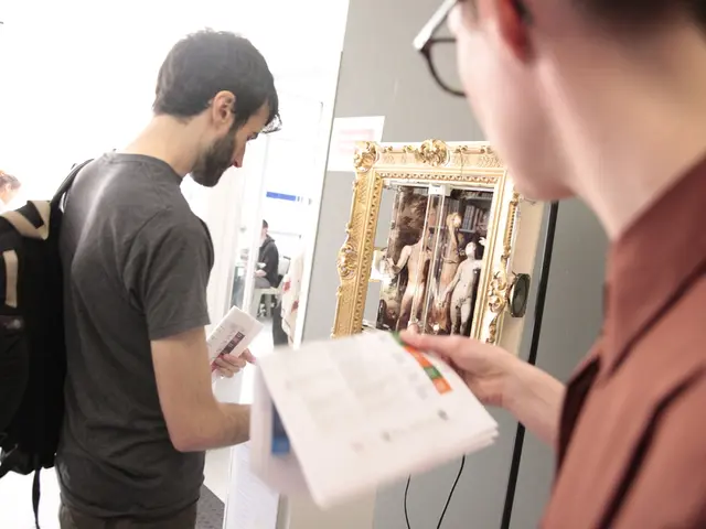 In this picture we can see two person standing, a person on the right side is holding papers, in...