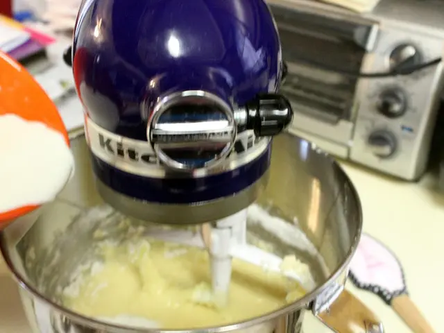 In the image there is a blending machine, inside that there is some item and on the left side some...