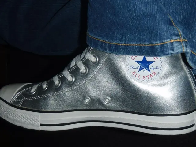 In this image there is a shoe. There is text on the shoe. There are shoe laces to the shoe. In the...