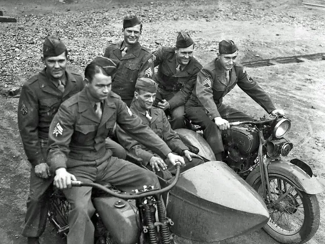 This is black & white picture. We can see all the men sitting on bikes and smiling. This is a road.