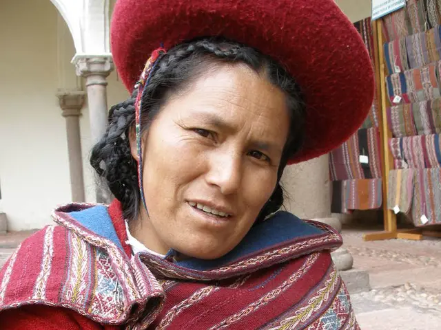 Here we can see a woman posing to a camera. In the background we can see pillars, clothes, and...