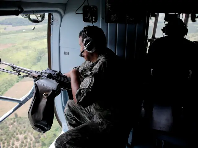 In the image we can see a person wearing army clothes, headsets and holding rifle in hand. It looks...