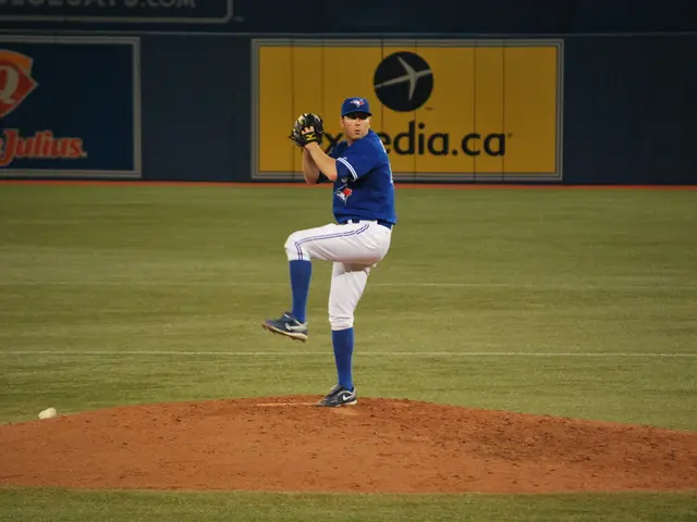 In this image there is a player standing on the ground and he is holding a ball in his hand. In the...