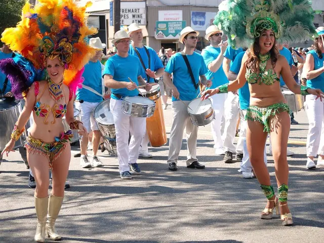 In this picture there two girls were dancing. And some of the men are wearing the blue t-shirt and...