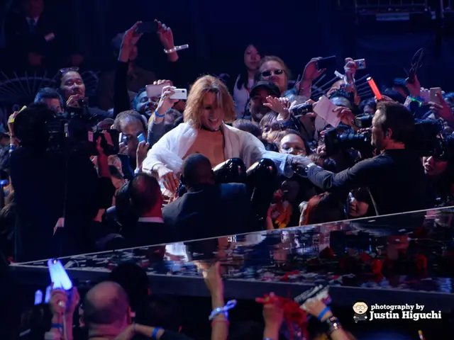 In the center of the image there is a stage. Behind the stage there are people and there is some...