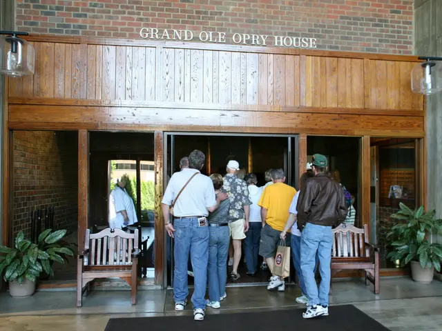 A group of people are going into a house there are lights on either side of this house and above...