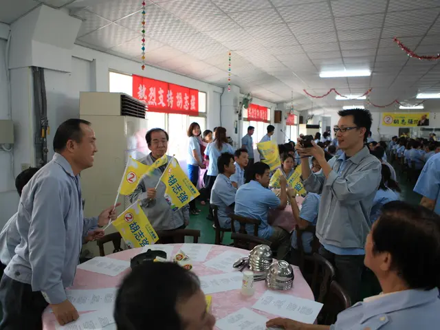 In this image there are papers, bowls, spoons, glasses on the table, and there is a person holding...