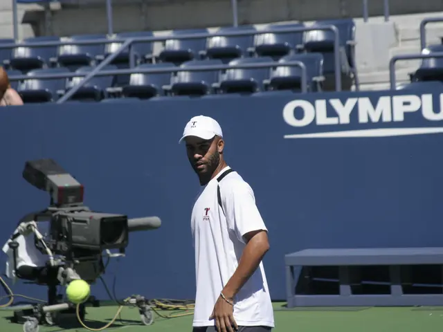 In this image there is a player, in front of the player there is a tennis ball in the air, behind...