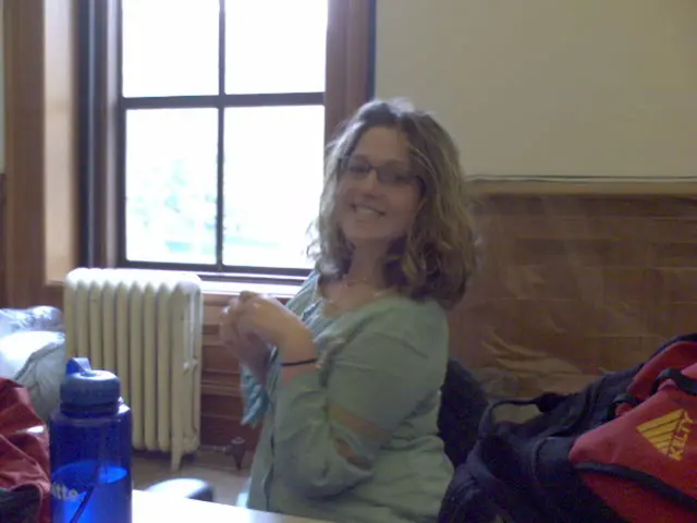 This image is taken indoors. In the background there is a wall with a window. In the middle of the...