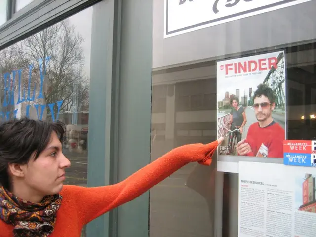 In this image, we can see a woman standing and she is pointing her finger at the poster, we can see...