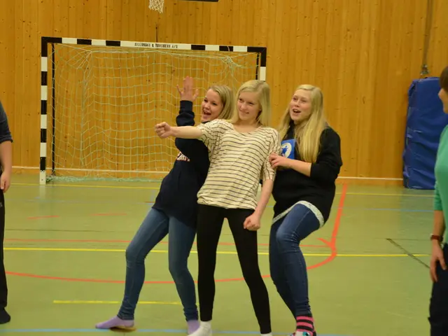 In this picture we can see five persons are standing, in the background there is a wall, we can see...