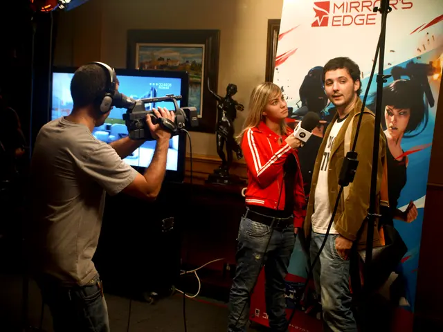 There are three members in this picture. One guy is holding a video camera, wearing a headset,...