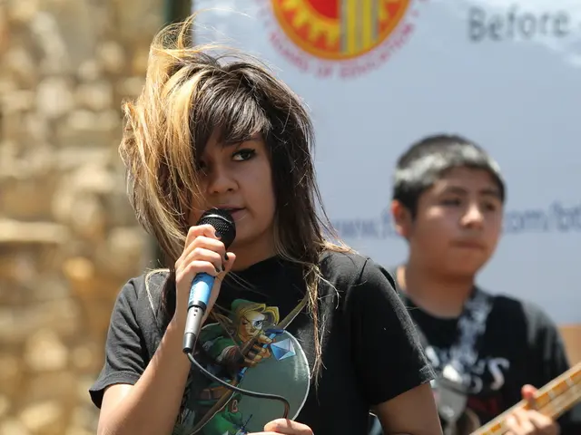 In this picture there is a girl at the center of the image, by holding a mic in her hand and there...