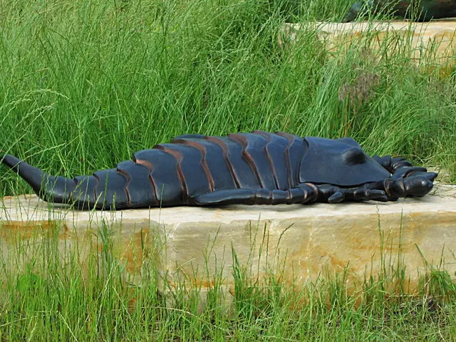 In this picture I can see there is a statue of a Scorpio, it is placed on the rock, there is grass...