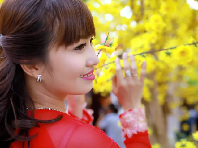 In this picture there is a Chinese girl wearing red color dress, smiling and looking on the right...