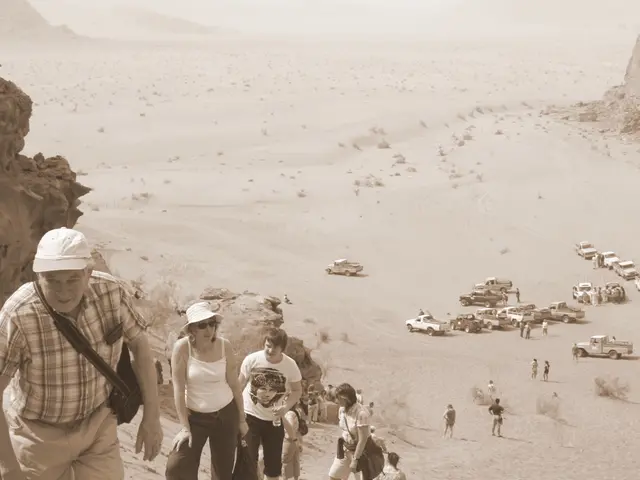 In this image we can see a desert. There are many people in the image. There are many vehicles in...