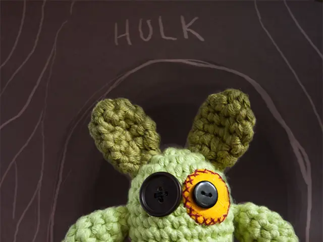 In the image there is a structure made up of woolen threads and buttons, behind that object it is...