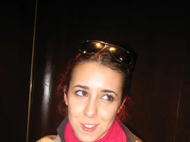 In this picture we can see a woman standing here, she wore a scarf, we can see goggles here.