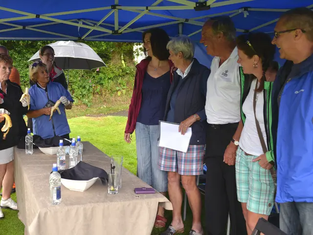 This image is taken in outdoors. In the right side of the image five people are standing, three men...